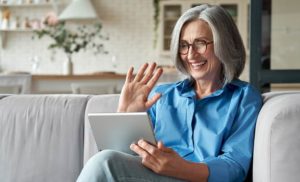 older adult waving to a family member on video chat